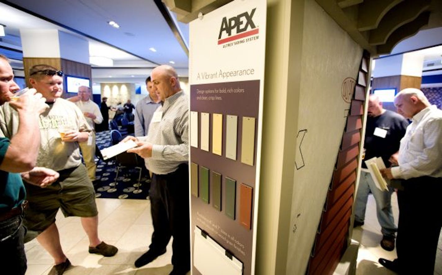 Matt Bonitas and John Bernard of Trilogy Homes listened as Scott Fox explained Marvin Windows and Doors' new Apex Ultrex Siding System. The new product was unveiled Monday at a reception for building professionals at the Champions Club room at Target Field in Minneapolis.