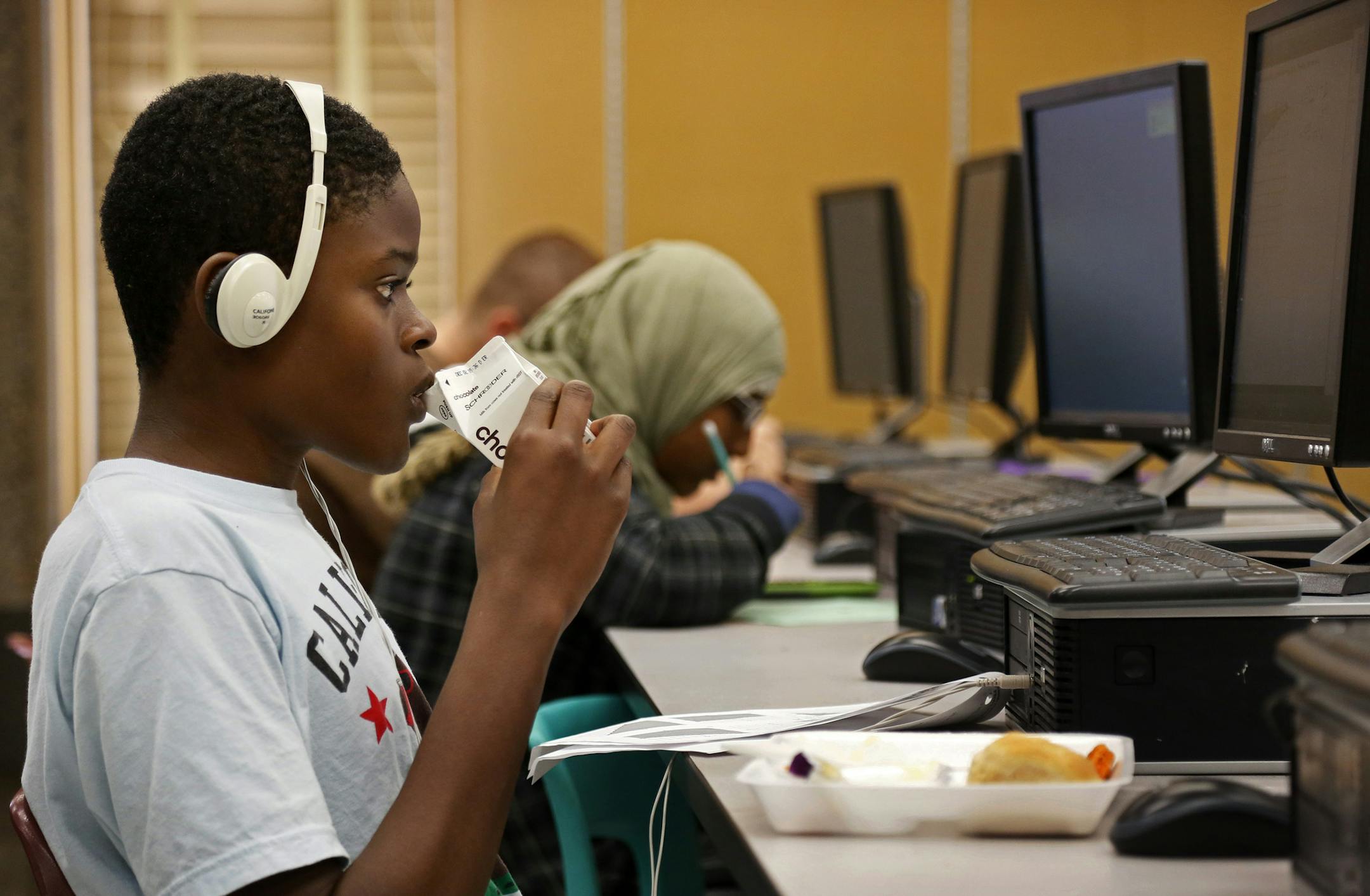 Anoka High School students who struggle with math but can't stay aftger school for help have discovered a new solution: lunchroom inteventions. The kids are allowed to go to the head of the lunch line, get their hot lunch and then eat itby their computer in a special room where they can re-take tests. Here, freshman Ibraheem Matti juggles his lunch with screen time as he takes a re-test during his lunch hour. ] Anoka, MN - 11/13//2013