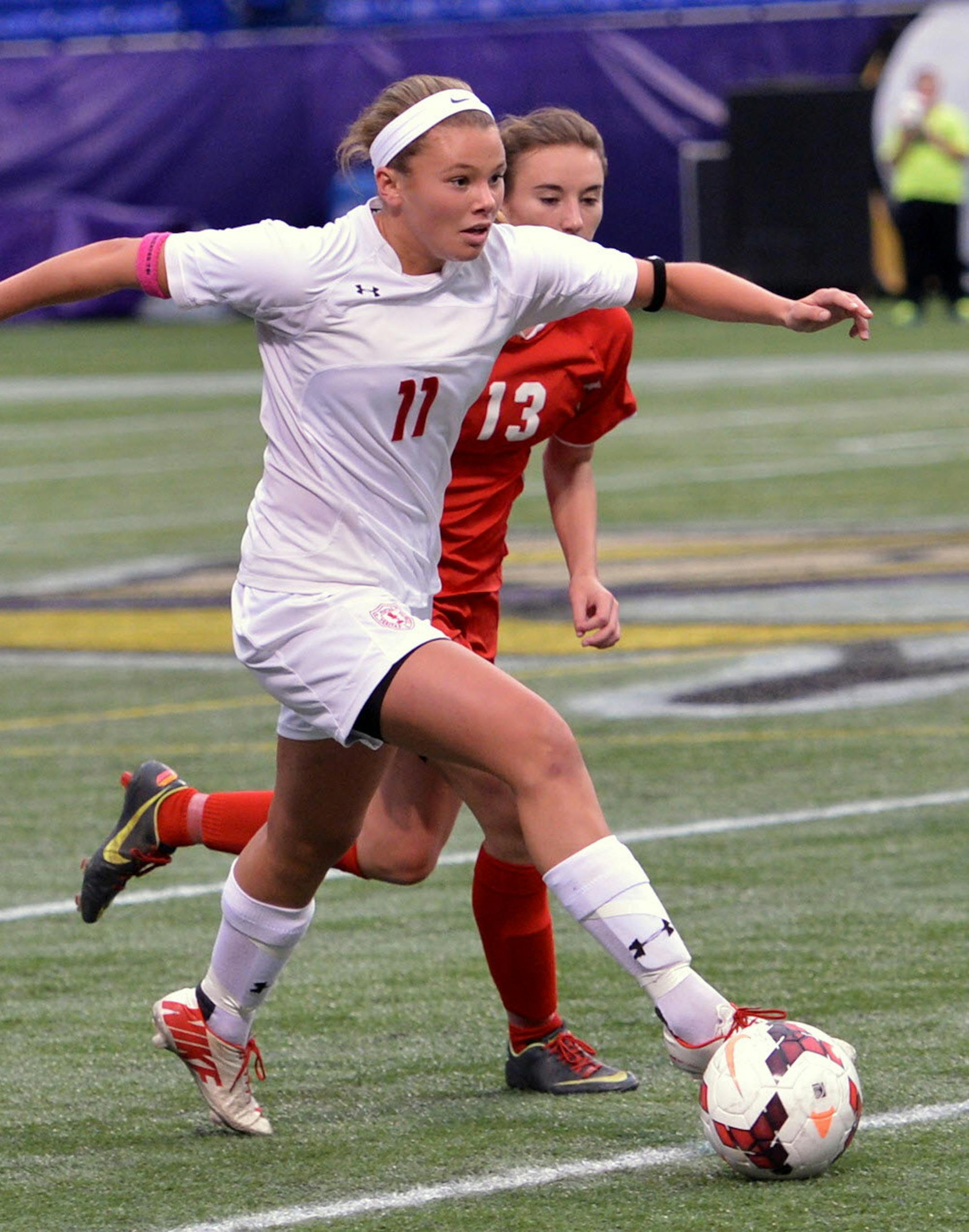 Benilde-St. Margaret senior Grace Coughlin moves the ball past Mankato West's Aisha Abdo during the second half of the Class 1A Girls' state soccer semifinal game Monday, October 28 at Metrodome. Benilde-St. Margaret came out victorious over Mankato West, 5-1. ] (SPECIAL TO THE STAR TRIBUNE/BRE McGEE) **Grace Coughlin (white, 11), Aisha Abdo (red, 13)