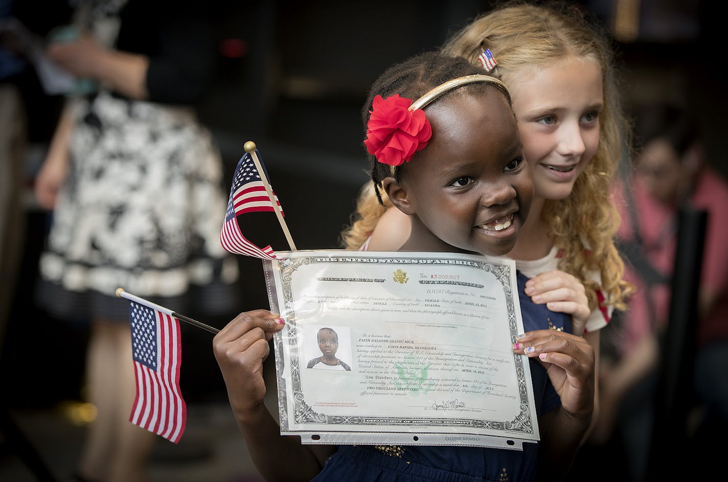 Faith Nasande Ssanyu Mick, 6, from Uganda, got a hug from her sister Ainsley Mick, 8, of Coon Rapids after she received her Certificate of Citizenship during a U.S. Citizenship and Immigration Services citizenship ceremony at the Minnesota Children's Museum, Friday, July 21, 2017 in St. Paul, MN. ] ELIZABETH FLORES &#xef; liz.flores@startribune.com