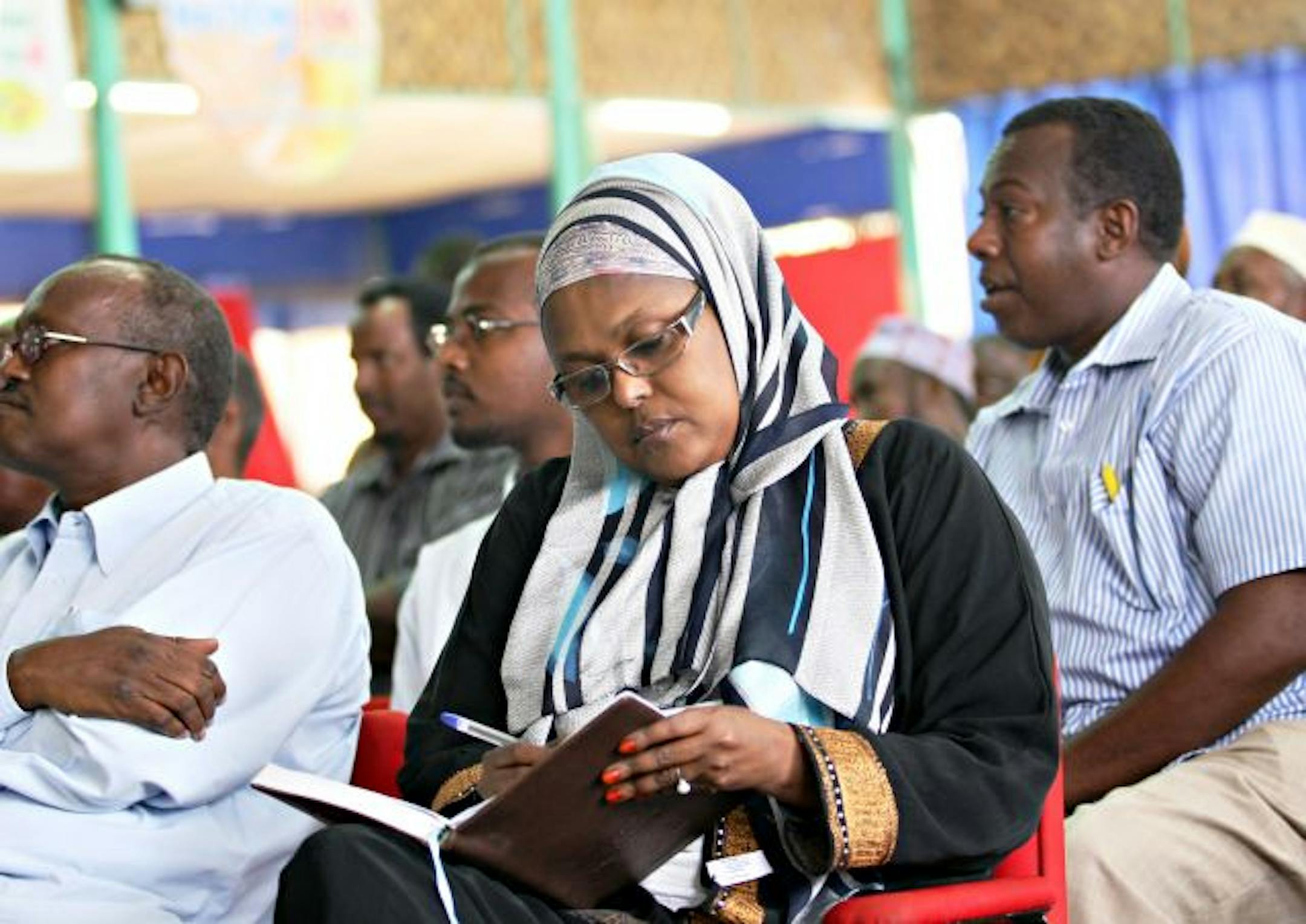 Somali Minister of Health Qamar Adan Ali (C) writes on her agenda moments before she was killed in a suicide bomb attack at a university student graduation ceremony in a local hotel in Mogadishu, Somalia on December 3, 2009. A suicide blast tore through a Mogadishu hotel on December 3, 2009 killing at least three ministers in Somalia's transitional government who were at a ceremony, officials said. Two journalists, one from Shabele Radio and another from Al Arabiya television, and a doctor were