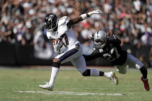 Baltimore Ravens wide receiver Mike Wallace (17) runs past Oakland Raiders free safety Reggie Nelson (27) during the second half of an NFL football ga