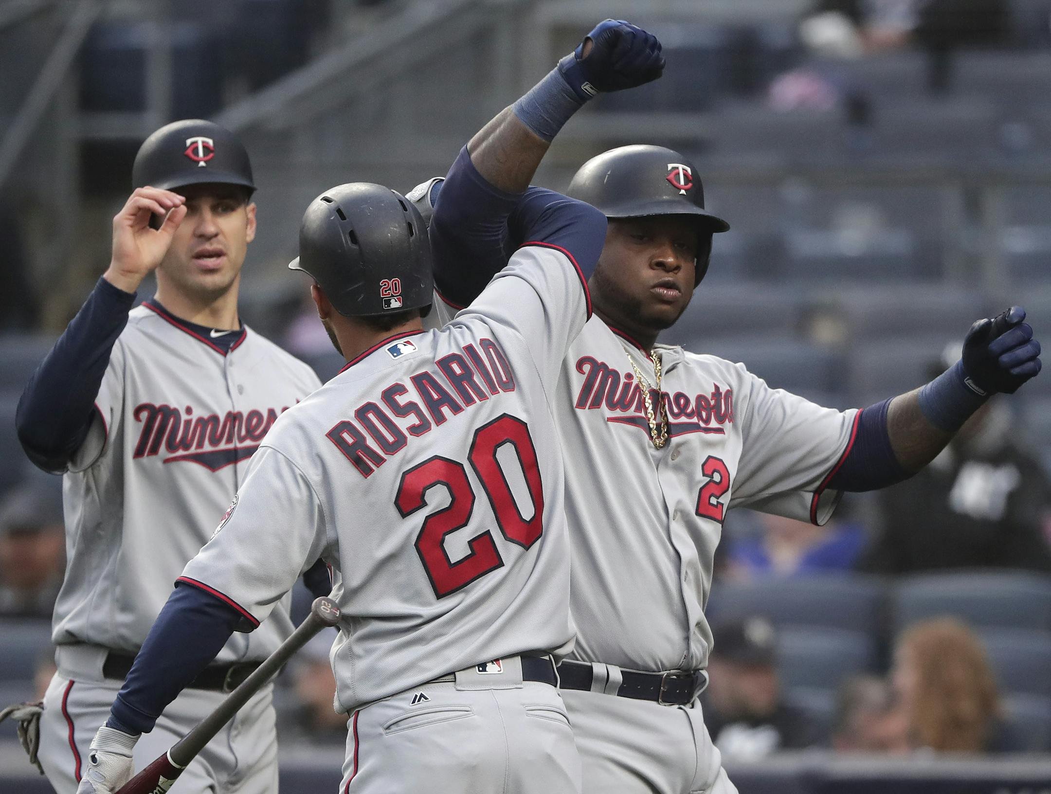 Minnesota Twins designated hitter Miguel Sano (22) celebrates with Eddie Rosario (20) and Joe Mauer (7) after hitting a two-run home run against the New York Yankees during the first inning of a baseball game, Wednesday, April 25, 2018, in New York. (AP Photo/Julie Jacobson)