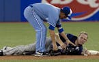 Toronto Blue Jays' John McDonald,left, checks on Minnesota Twins Justin Morneau, on July 7, 2010 -- the play that resulted in a concussion that ended 