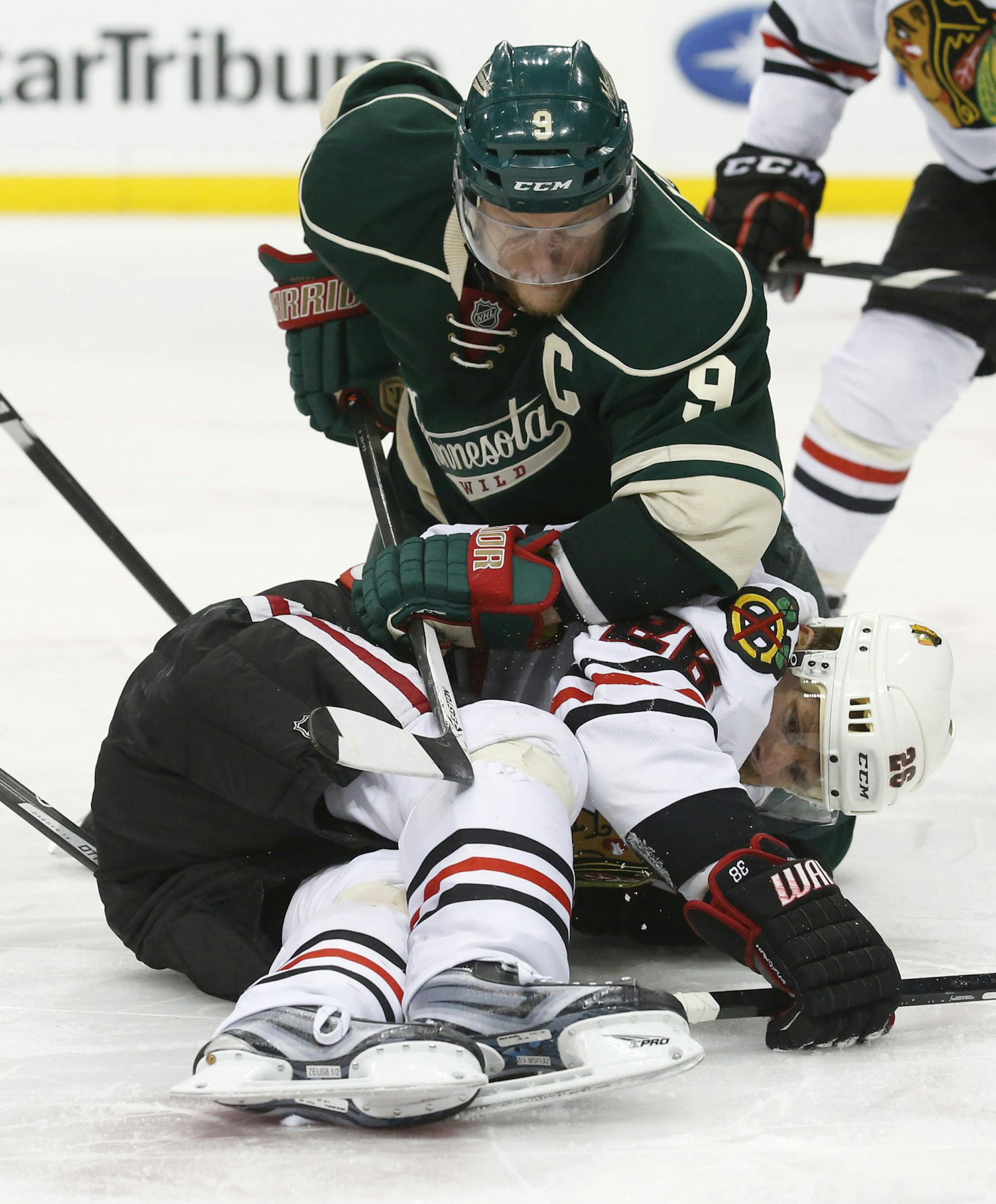 During the 2014 playoffs, Minnesota Wild center Mikko Koivu tried to get at the puck, which Chicago Blackhawks center Michal Handzus was laying on during the third period.