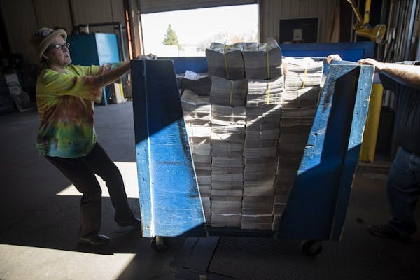Jana Peterson helps move a bin full of the second issue of the Pine Knot News to stack in a truck.
