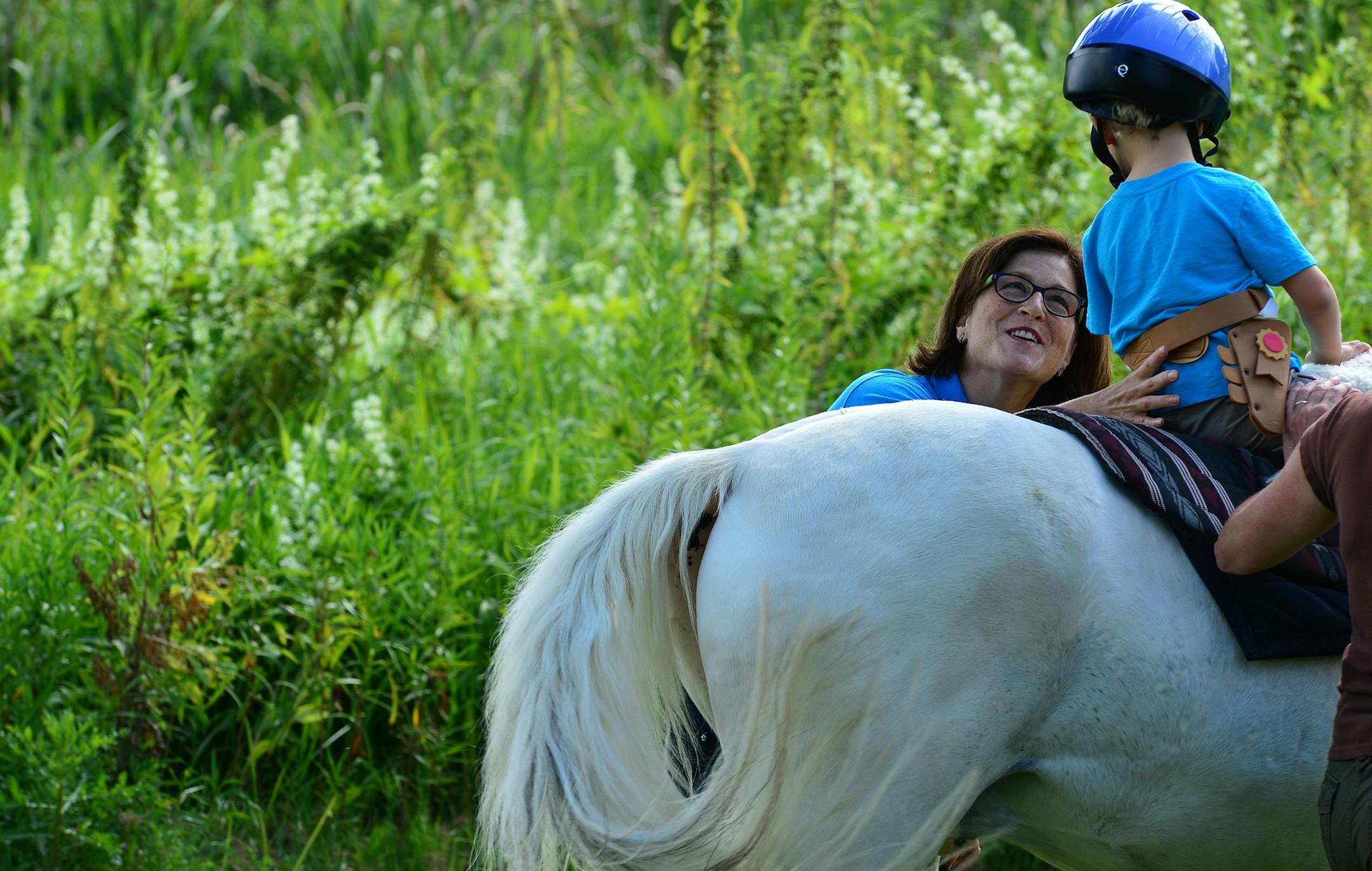 Former PR and marketing executive Janet Weisberg founded Hold Your Horses to pursue that combines working with horses to offer equine-assisted occupational therapy to people with physical, cognitive or other impairments. Janet Weisberg interacted with a young client on a pony during a riding lesson ] Richard.Sennott@startribune.com Richard Sennott/Star Tribune Independence, Minnesota Wednesday 8/14/13) ** (cq) ORG XMIT: MIN1308150846322926