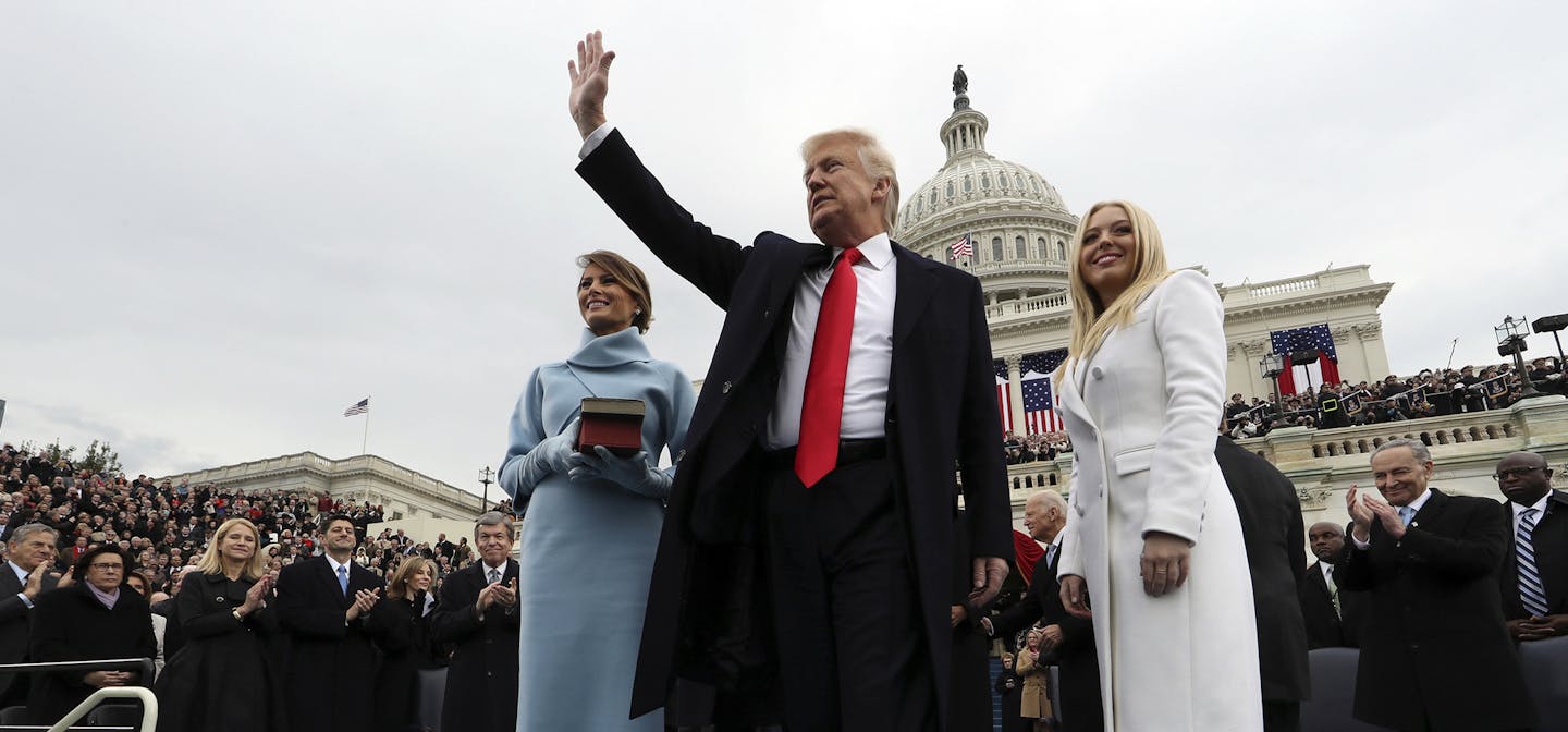 President Donald Trump waves after taking the oath of office as his wife Melania holds the Bible, and Tiffany Trump looks out to the crowd, Friday, Jan. 27, 2017 on Capitol Hill in Washington. (Jim Bourg/Pool Photo via AP) ORG XMIT: MIN2017012016250701