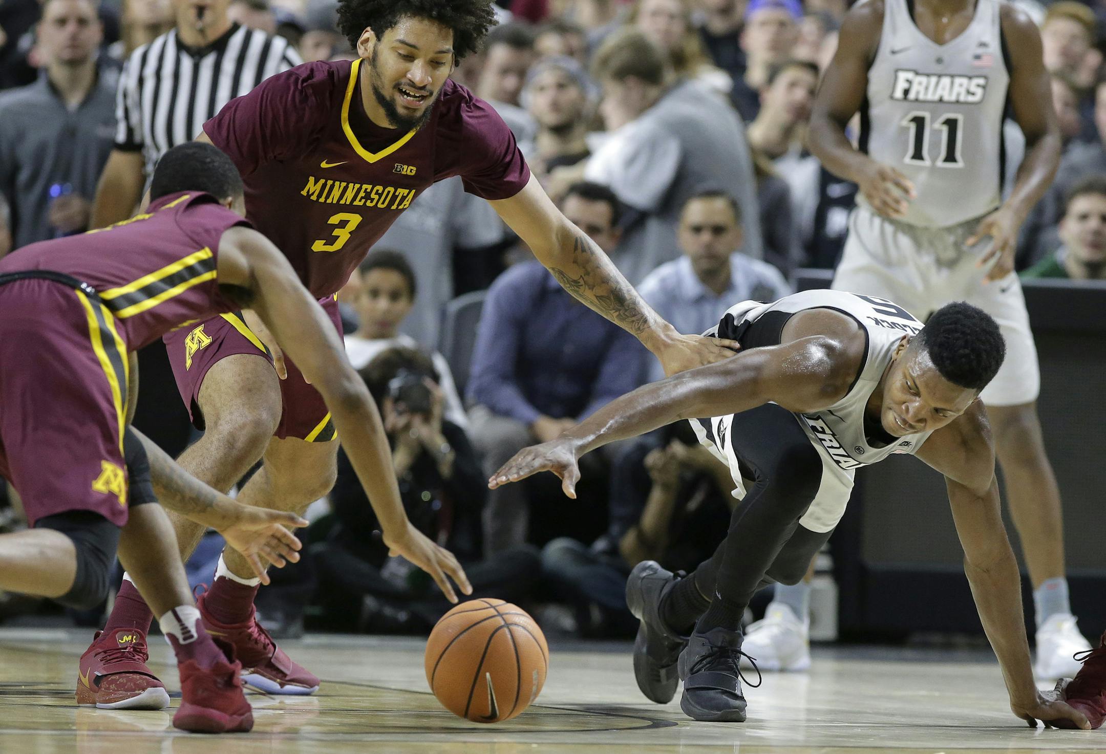 Minnesota's Dupree McBrayer, left, and Jordan Murphy (3) vie with Providence's Rodney Bullock, right, for the ball in the first half of an NCAA college basketball game Monday, Nov. 13, 2017, in Providence, R.I. (AP Photo/Steven Senne)