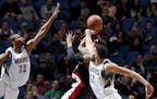 Andrew Wiggins (22) and Karl-Anthony Towns attempted to block a shot by Damian Lillard (0) in the fourth quarter.