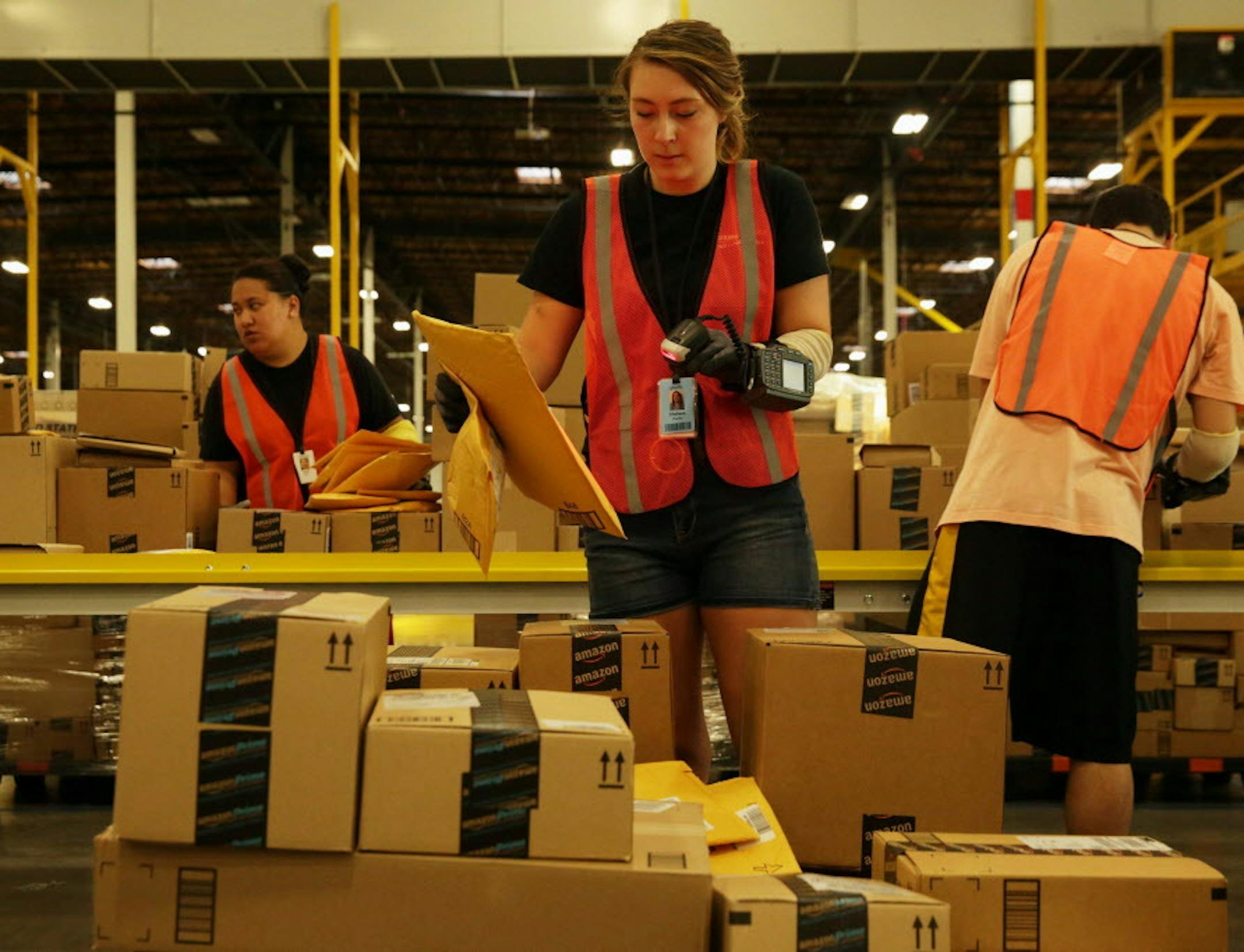 Chelsea Pfeiffer scans items at Amazon's new sortation center in Kent, Wash. "Tens of thousands" of packages will go through the facility. (Erika Schultz/The Seattle Times/MCT) ORG XMIT: 1155291