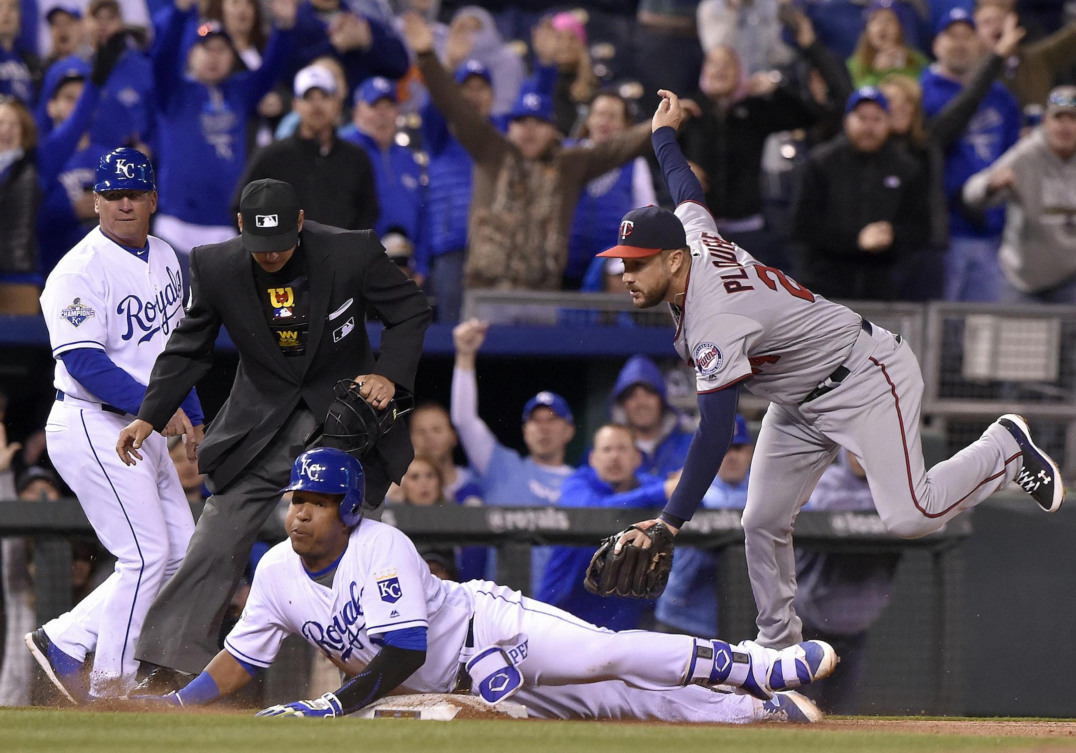 The Kansas City Royals' Salvador Perez slides into third with an RBI triple before the tag from Minnesota Twins third baseman Trevor Plouffe, right, in the eighth inning on Friday, April 8, 2016, at Kauffman Stadium in Kansas City, Mo. (John Sleezer/Kansas City Star/TNS)