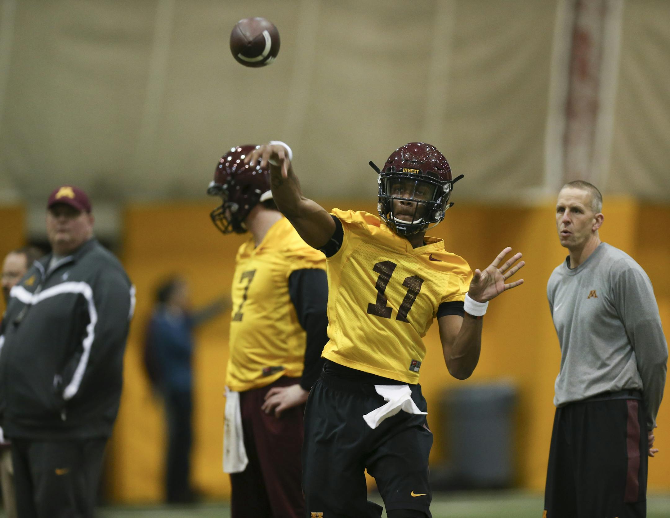 Head coach Tracy Claeys, left, and his new offensive coordinator Jay Johnson, right both watched sophomore quarterback Demry Croft throw during a drill .