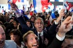 Supporters of French far-right National Rally react at the party election night headquarters, Sunday in Paris. First projected results from France put