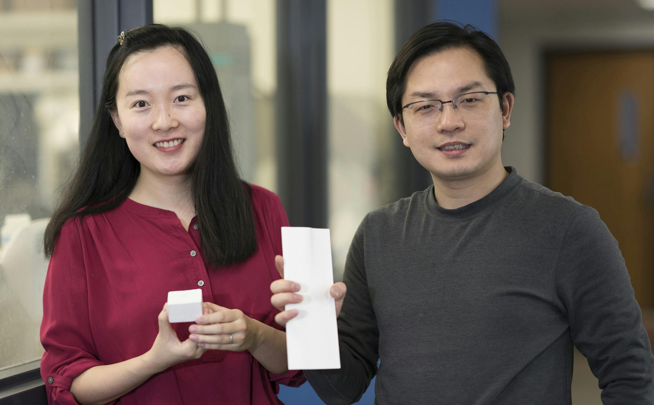 Tian Li, left, and Liangbing Hu hold pieces of nanowood, a strong, lightweight material that serves as an effective insulator. (Hua Xie/University of Maryland) ORG XMIT: 1225677