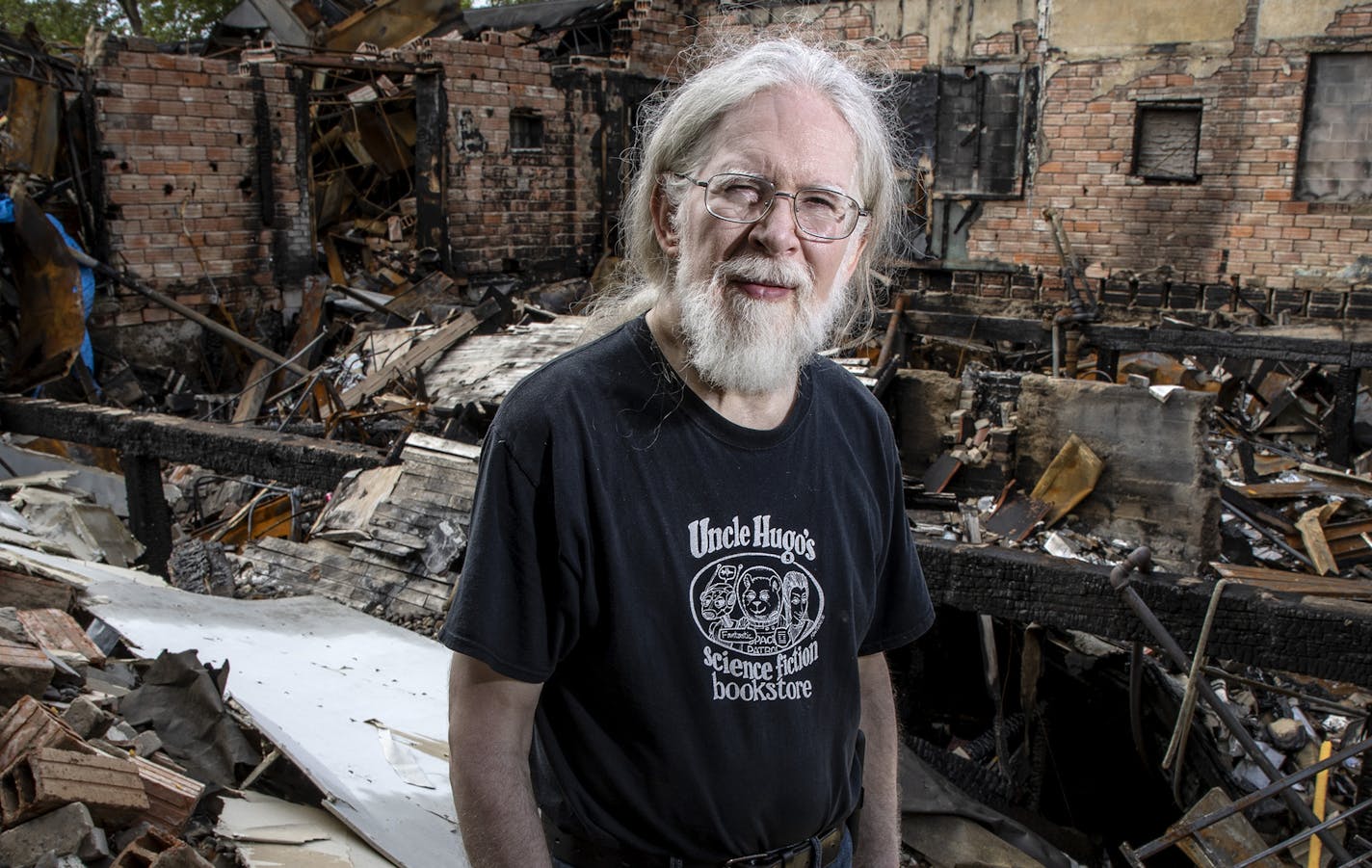 Don Blyly stood on the ruins of Uncle Hugo's Science Fiction & Uncle Edgar's Mystery Bookstores in Minneapolis. ] CARLOS GONZALEZ • cgonzalez@startribune.com – Minneapolis, MN – August 12, 2020, portrait of Don Blyly, the owner of Uncle Hugo's and Uncle Edgar's bookstores