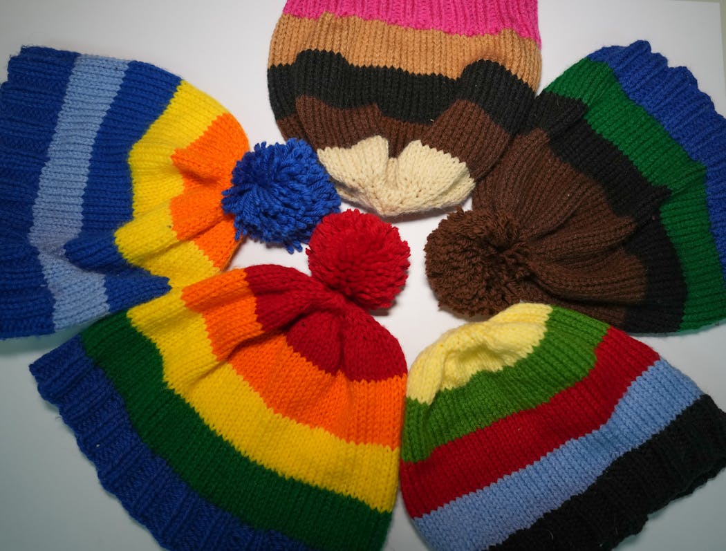 Some of the hats Samantha Monson’s mother, Debbie, and sister Emma knitted for her class.