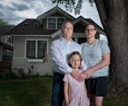 Jon and Karli Neilson with their daughter Parker, 6, in front of their home in St. Paul. They recently discovered the deed to their home contains a ra