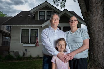 Jon and Karli Neilson with their daughter Parker, 6, in front of their home in St. Paul. They recently discovered the deed to their home contains a ra