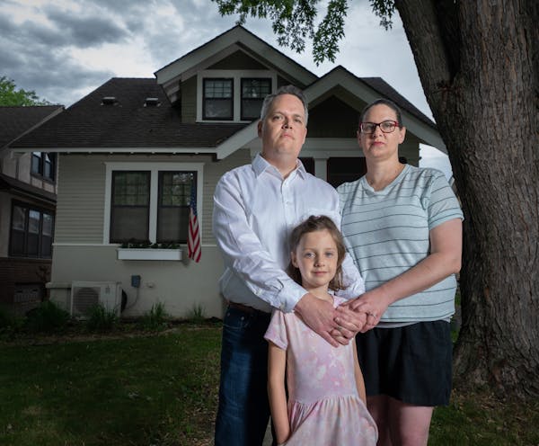 Jon and Karli Neilson with their daughter Parker, 6, in front of their home in St. Paul. They recently discovered the deed to their home contains a ra