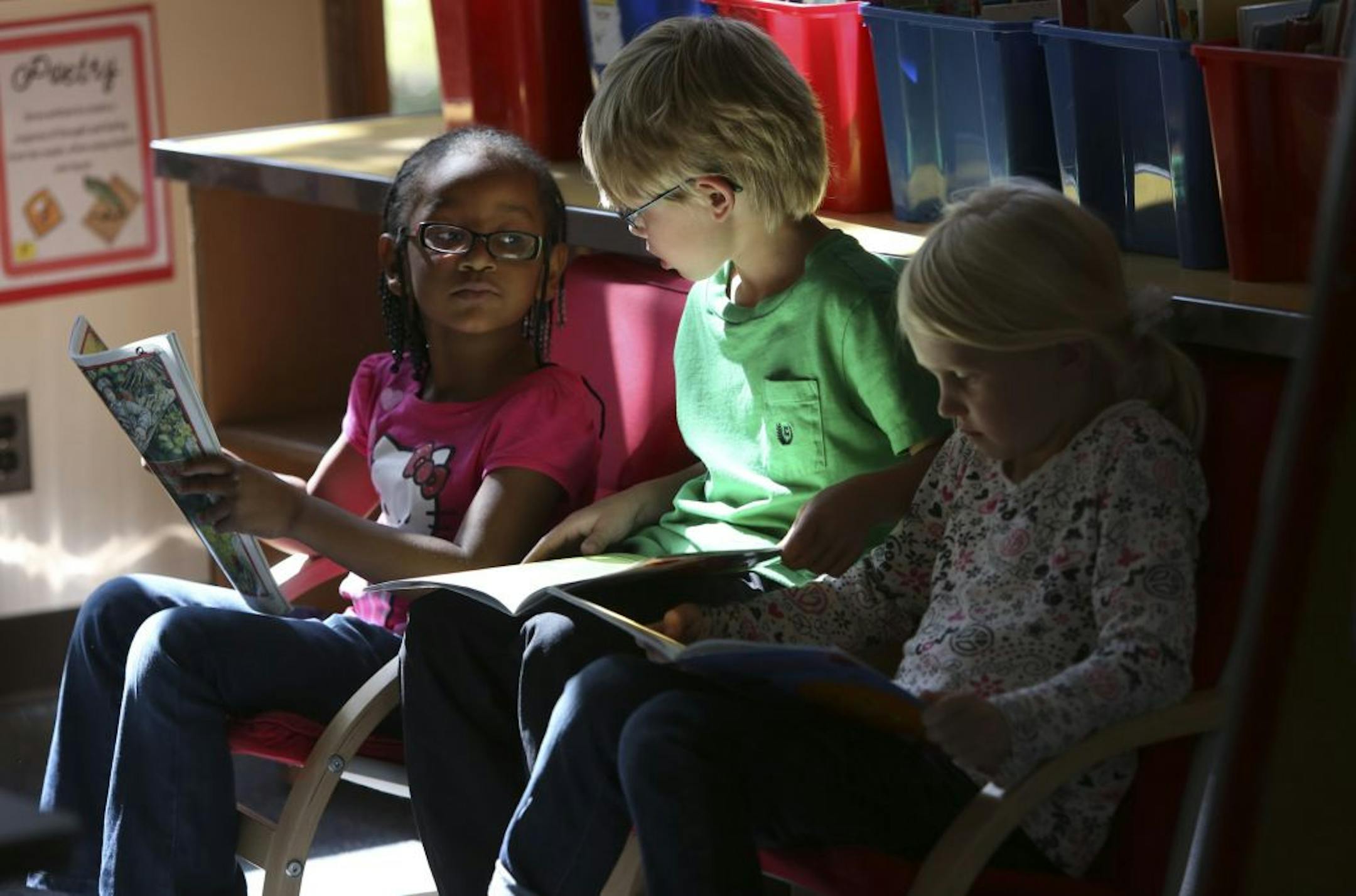 Kindergarteners Kiara Richardson, Hart Hokens and Lauren Pflieger read during class Tuesday at Kenny Community School in Minneapolis, which saw one of the biggest increases in overall test scores in the metro area.