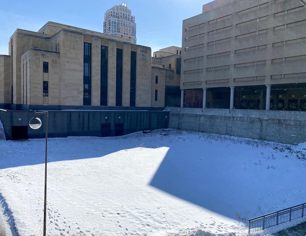 An empty field on the riverfront, and where a park should be. The post office’s 1970s parking ramp, right, is a seven-story impediment between the riverfront from Gateway Park. 