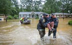 DNR officer Brett Irvin and Lexington Co. Deputy Dan Rusinyak carry June Loch to dry land after she was rescued from her home in the Pine Glen subdivi