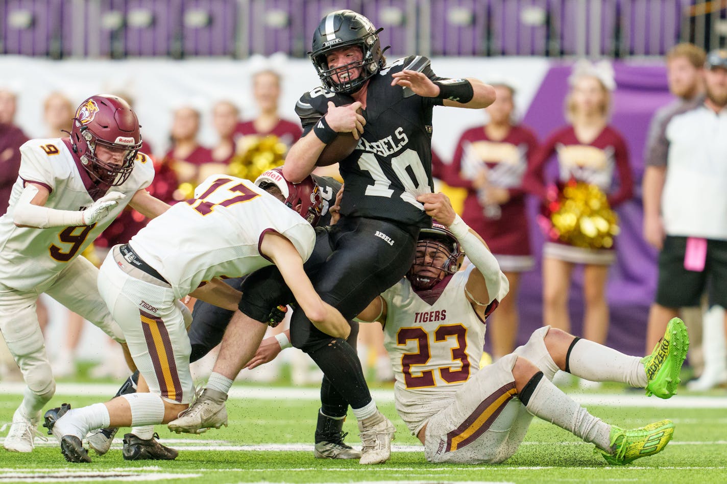 Dilworth-Glyndon-Felton quarterback Caleb Johnson (18) is tackled by Stewartville defensive back Dylan Hoot (17) and linebacker Mikhail Heydt (23) in the Class 3A state semifinal football game between Stewartville and Dilworth-Glyndon-Felton played at U.S. Bank Stadium on Friday, Nov. 17, 2023. Photo by Matt Blewett, Special to Star Tribune matt@mattebphoto.com