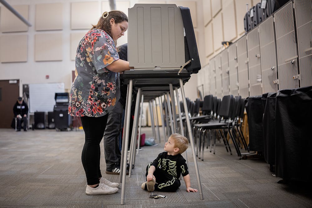 Samantha King votes as her son Luka Kind finds a spot to “hide” at Shakopee West Middle School in Shakopee, MN on Tuesday, Nov. 5, 2024.   ] Elizabeth Flores • liz.flores@startribune.com