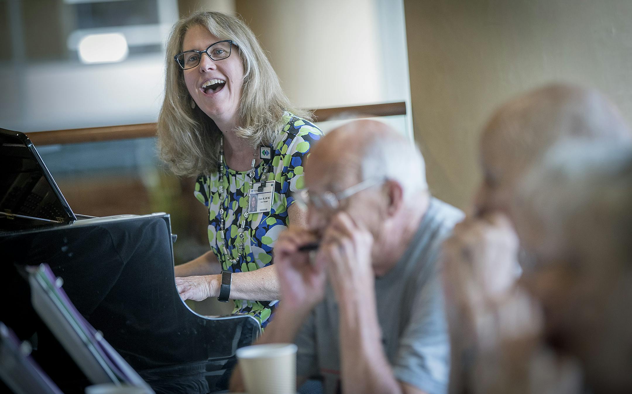 Dawn McDougal Miller played the piano as she led a group of patients play their harmonicas during a concert at Methodist Hospital, Thursday, June 28, 2018 in St. Louis Park, MN. Patients with COPD or other breathing-related disorders have been prescribed harmonicas, which they use for fun, but also to augment their usual pulmonary rehab drills and exercises. ] ELIZABETH FLORES ï liz.flores@startribune.com