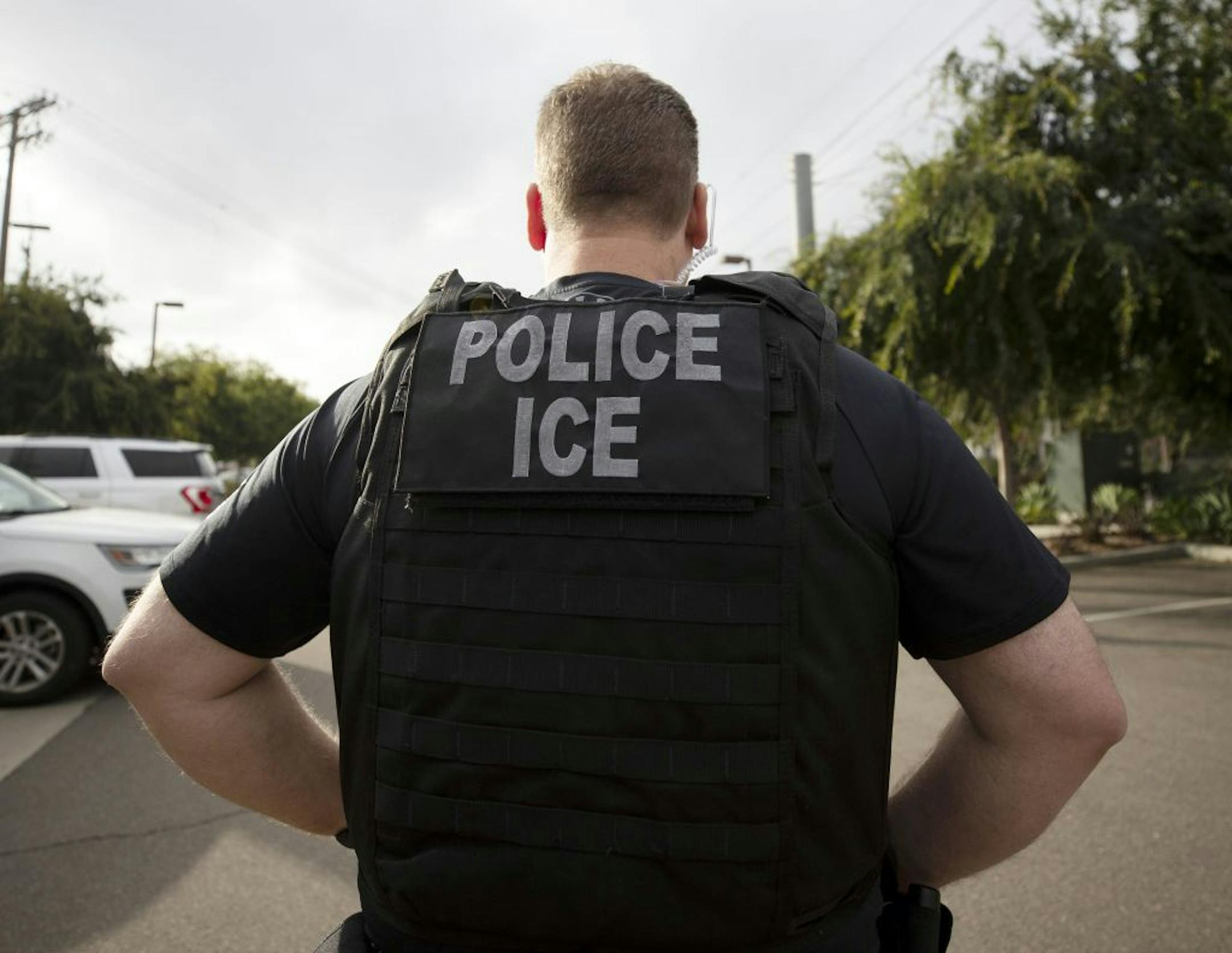 FILE - In this July 8, 2019, file photo, a U.S. Immigration and Customs Enforcement (ICE) officer looks on during an operation in Escondido, Calif. International students will be forced to leave the U.S. or transfer to another college if their schools offer classes entirely online this fall, under new guidelines issued Monday by federal immigration authorities. The guidelines, issued by U.S. Immigration and Customs Enforcement, provide additional pressure for campuses to reopen even amid growing