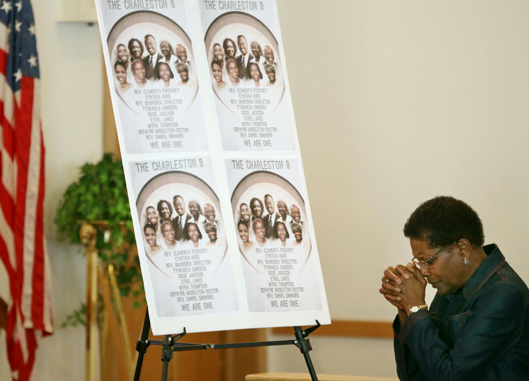 Gwen Fraction, a member of the St. Peter's AME church since 1957, prayed near a collections of photographs of the 9 people that were killed last week in Charleston, S.C.,
