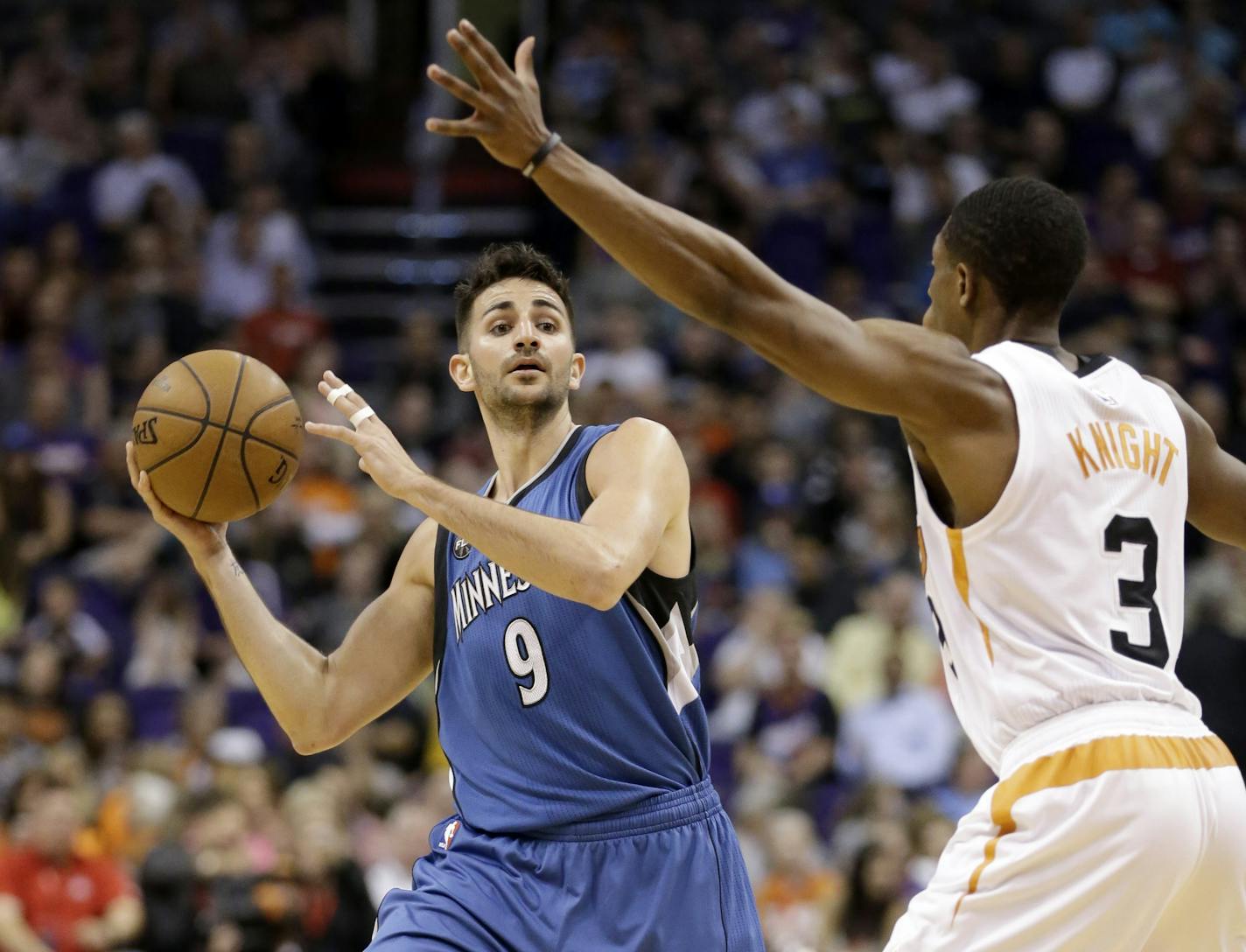 Minnesota Timberwolves' Ricky Rubio (9) looks to pass around Phoenix Suns' Brandon Knight during the first half of an NBA basketball game, Monday, March 14, 2016, in Phoenix. (AP Photo/Matt York)