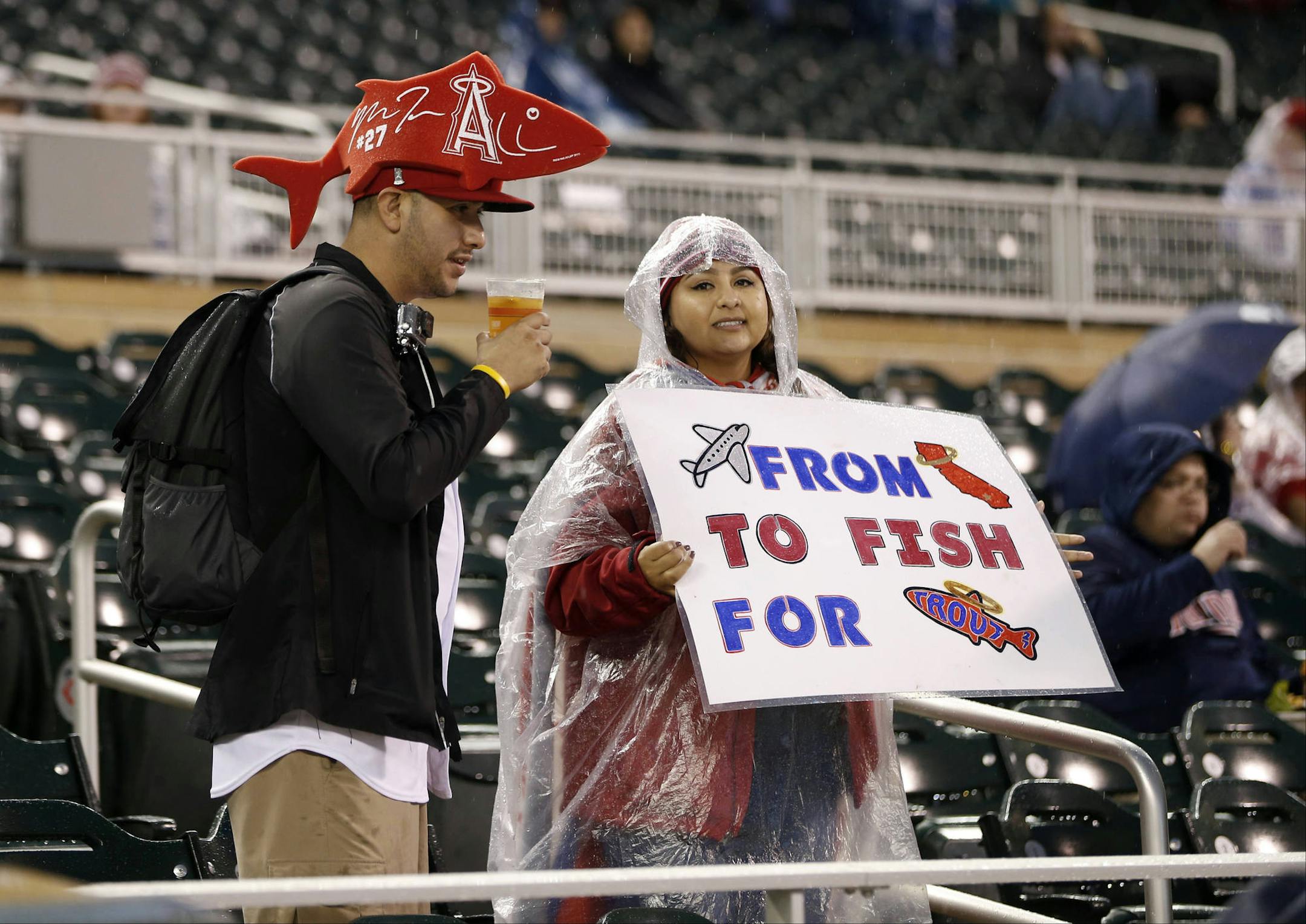 Fans of Los Angeles Angels' Mike Trout wait during a rain delay prior to a baseball game between the Angels and Minnesota Twins, Friday, Sept. 18, 2015, in Minneapolis. (AP Photo/Jim Mone)