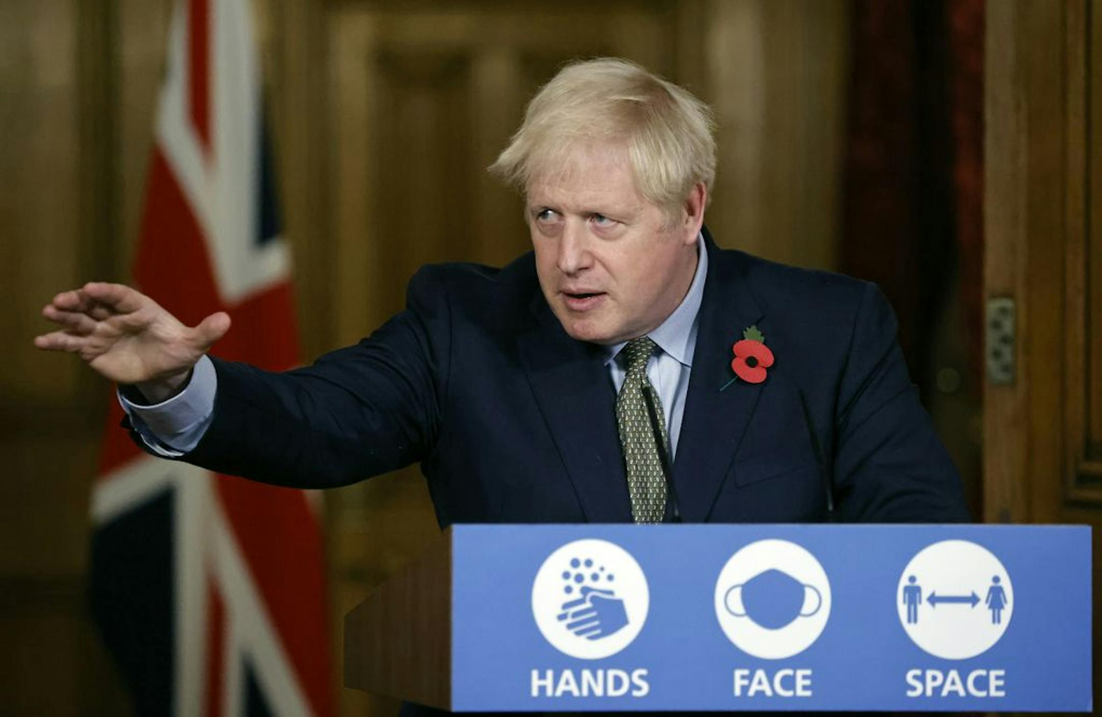 FILE - In this Nov. 9, 2020 file photo Britain's Prime Minister Boris Johnson reaches out during a virtual press conference on the coronavirus pandemic at 10 Downing Street in central London. Johnson is self-isolating after being told he came into contact with someone who tested positive for the coronavirus, officials said Sunday Nov. 15. "He will carry on working from Downing Street, including on leading the government's response to the coronavirus pandemic," a statement from his office said.