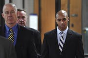 Former Minneapolis police officer Mohamed Noor, right, with attorneys Peter Wold, center, and Thomas Plunkett, left, walks out of the the Hennepin Cou