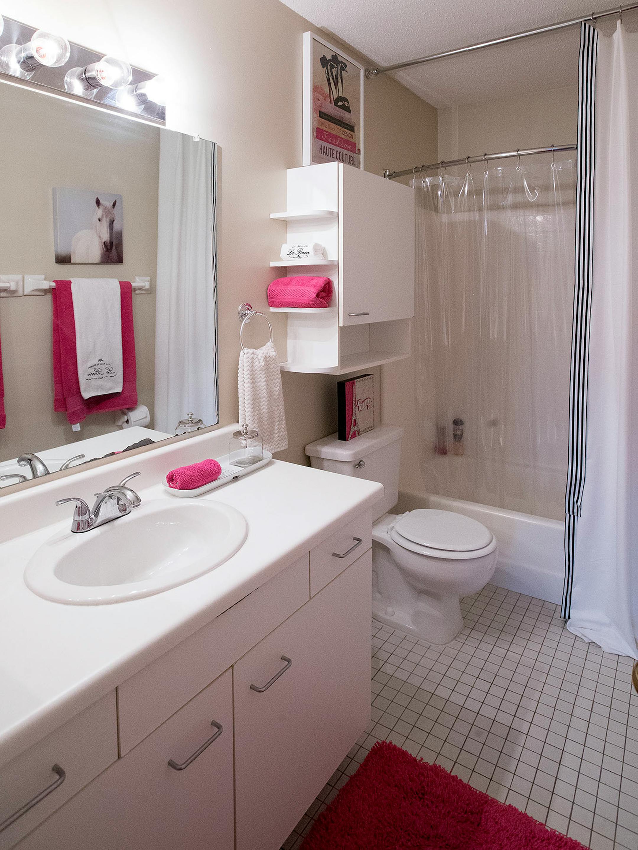 A drapery side panel trimmed with ribbon dresses up a plain shower curtain.