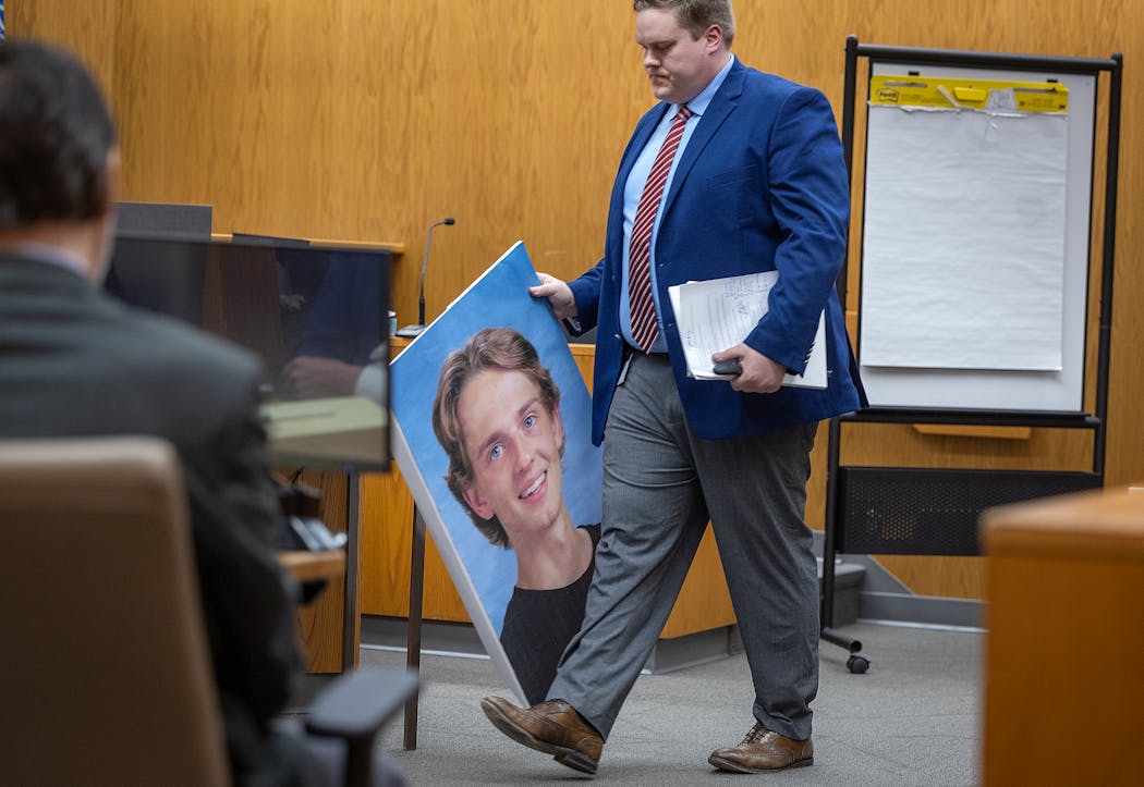 St. Croix County District Attorney Karl Anderson carried a photo of Isaac Schuman after he placed it in front of the jury during the Nicolae Miu trial at the St. Croix County District Court in Hudson on Monday.