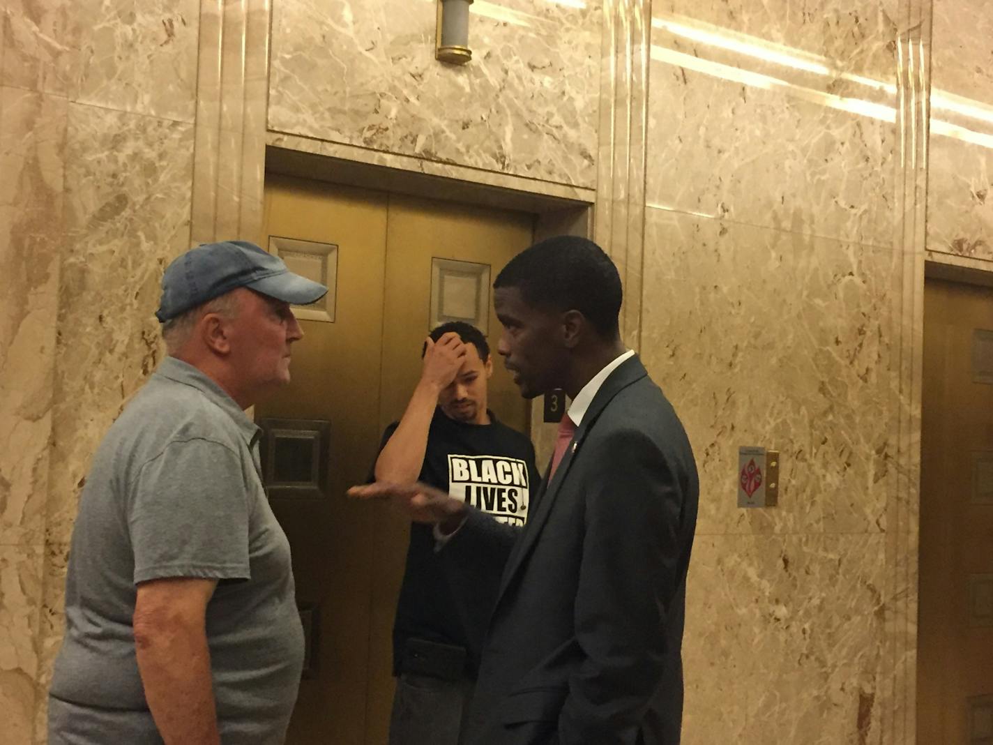 St. Paul Mayor Melvin Carter talks to Carl Roith (left), a Frogtown resident who came to City Hall Wednesday to advocate for more police.