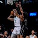 Nickeil Alexander-Walker looks to pass the ball while defended by Brooklyn Nets guard Dennis Smith Jr. on Thursday.