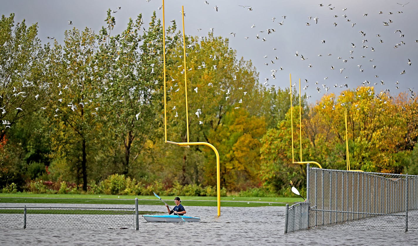 Justin Sampson, a member of the Waseca High School football team, checked out the flooding on the field from a kayak.