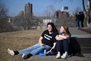 Malia Breezee and best friend Greta Perpich, both freshman at Augsburg University, relax in the sunlight atop the hill at Gold Medal Park in Minneapol