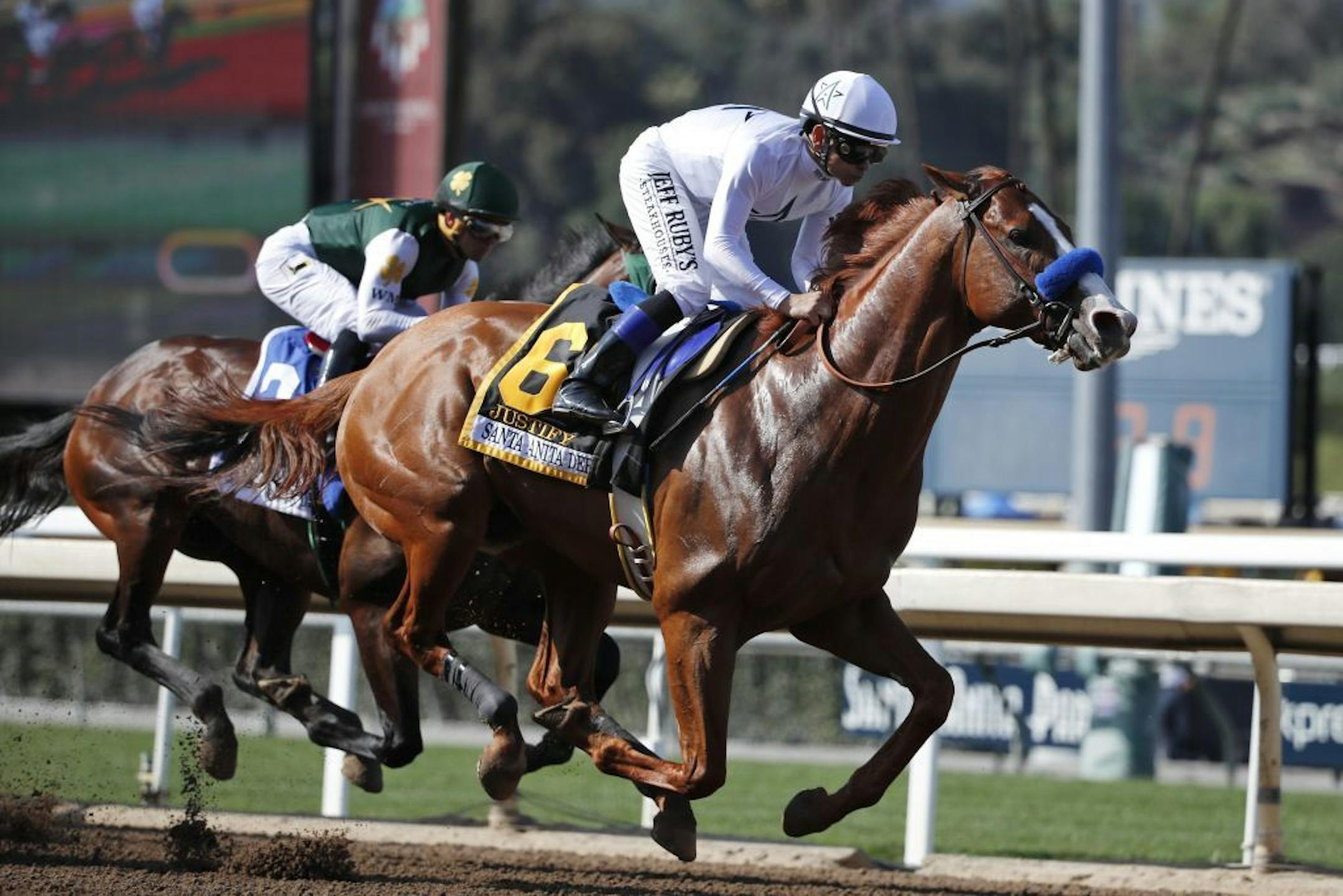 Justify, ridden by Mike Smith, gallops past Bolt d'Oro, left, with jockey Javier Castellano, during the Santa Anita Derby in April 2018.