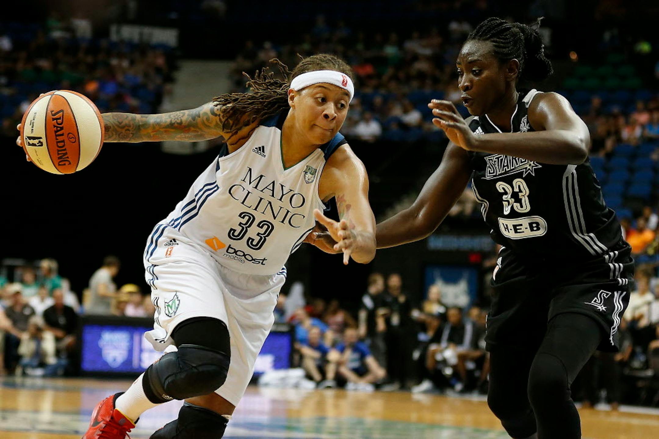Minnesota Lynx guard Seimone Augustus (33) drives the ball past San Antonio Stars forward Sophia Young-Malcolm (33) during the second half of a WNBA basketball game, Sunday, July 12, 2015, in Minneapolis. The Lynx won 66-49. (AP Photo/Stacy Bengs)