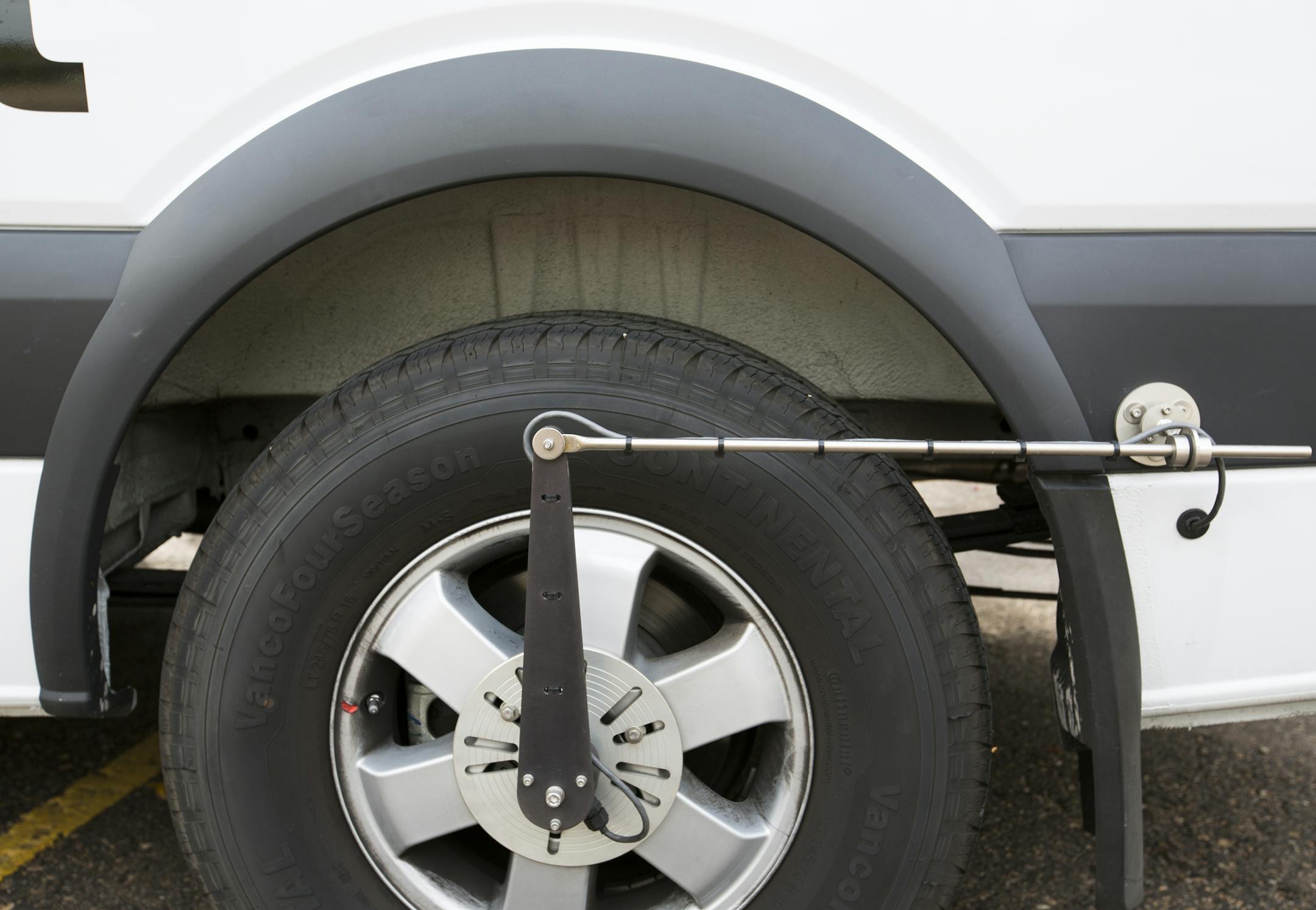 A distance measuring instrument is mounted on the Dynatest van&#x2019;s tire.