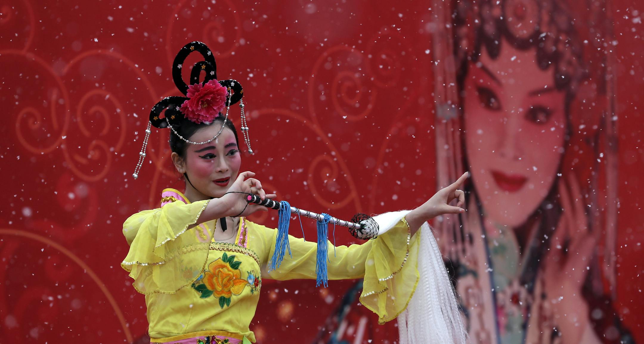A Chinese dancers dressed in traditional costume perform in a cultural dance in the snow at the Ditan Park during a temple fair for a Lunar New Year celebration in Beijing Friday, Feb. 20, 2015. (AP Photo/Andy Wong)