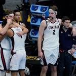 Gonzaga forward Corey Kispert (24) hugs Jalen Suggs (1) as Gonzaga forward Drew Timme (2) looks on at the end of the championship game against Baylor 