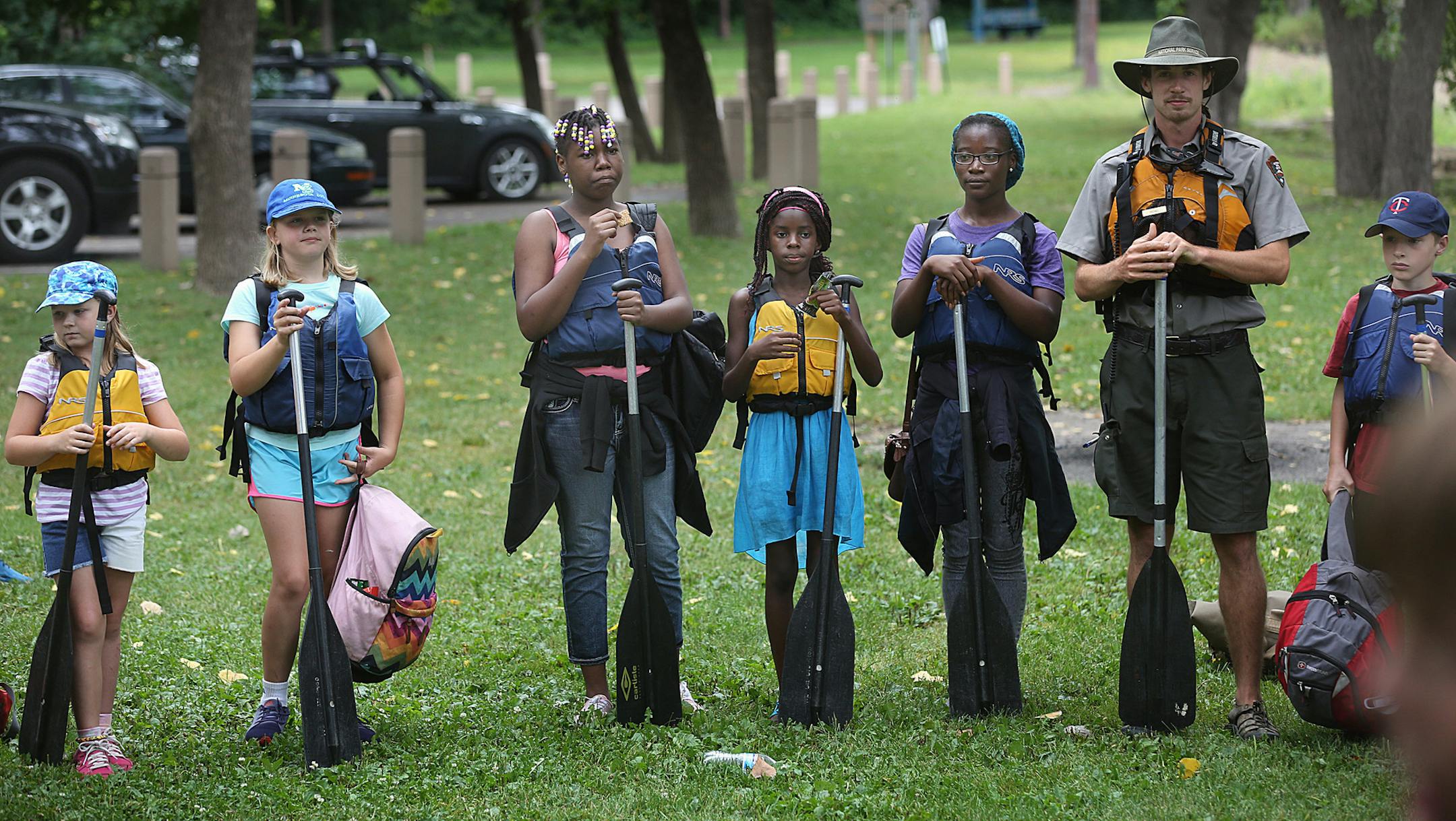 Michael Anderson, a park ranger with the National Park Service, listened with children in his group to paddling and safety instructions before they headed out on to the river. ] JIM GEHRZ &#xef; james.gehrz@startribune.com / St. Paul, MN / August 7, 2015 / 11:00 AM &#xf1; BACKGROUND INFORMATION: Wilderness Inquiry is leading a paddle for YMCA children, starting at Hidden Falls Regional Park. Photos of children on canoe outing.