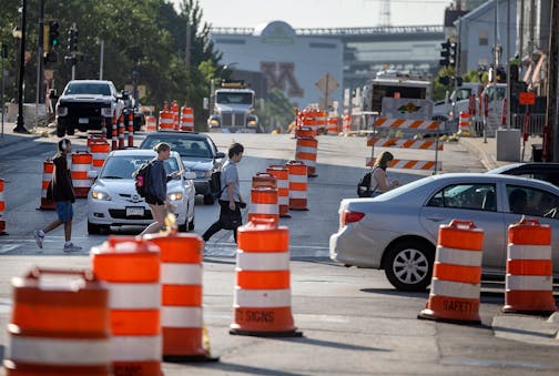 Foot, bike, and car traffic make their way along the construction on 4th Street SE near the University of Minnesota in Minneapolis on Aug. 8, 2024.