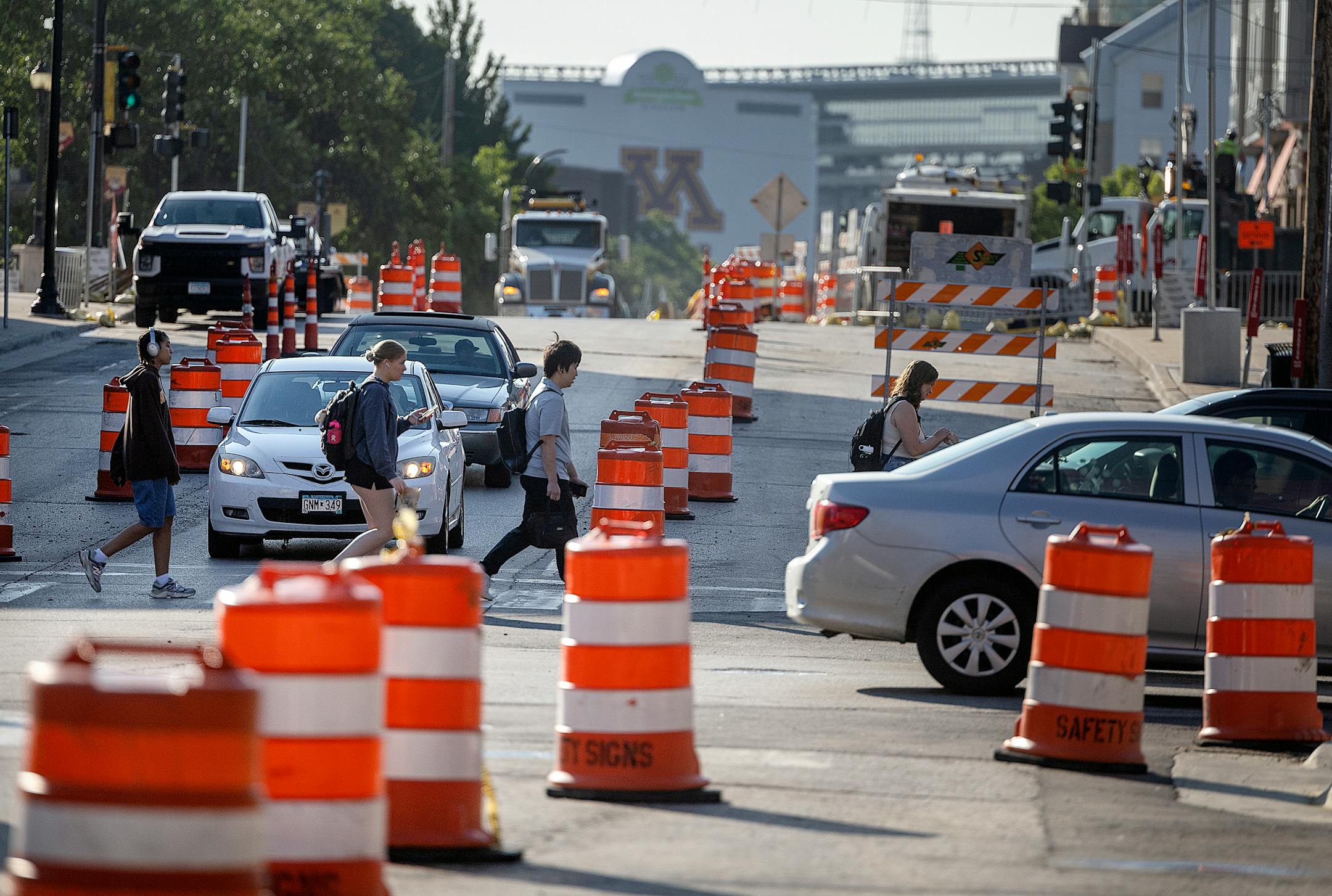 Foot, bike, and car traffic make their way along the construction on 4th Street SE near the University of Minnesota in Minneapolis on Aug. 8, 2024.